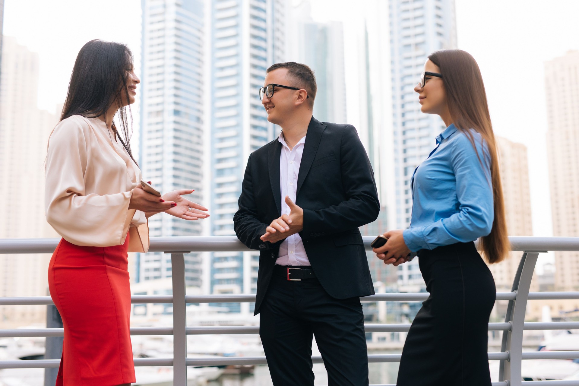 Businessman and two woman discussing about a meeting in the city. Three business people talking at business center outdoor.